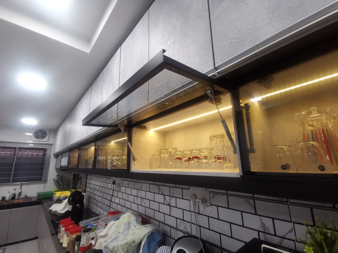 Glass-front upper kitchen cabinet with a door shown open