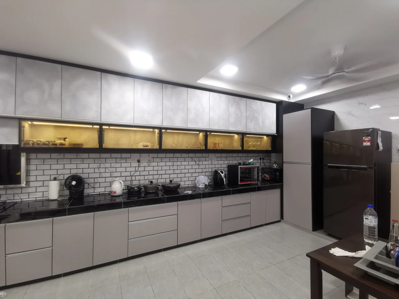 Grey kitchen cabinetry with illuminated glass-front upper cabinets